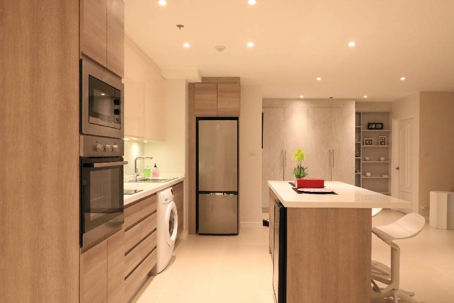 Condo kitchen renovation with wood-tone cabinetry and island