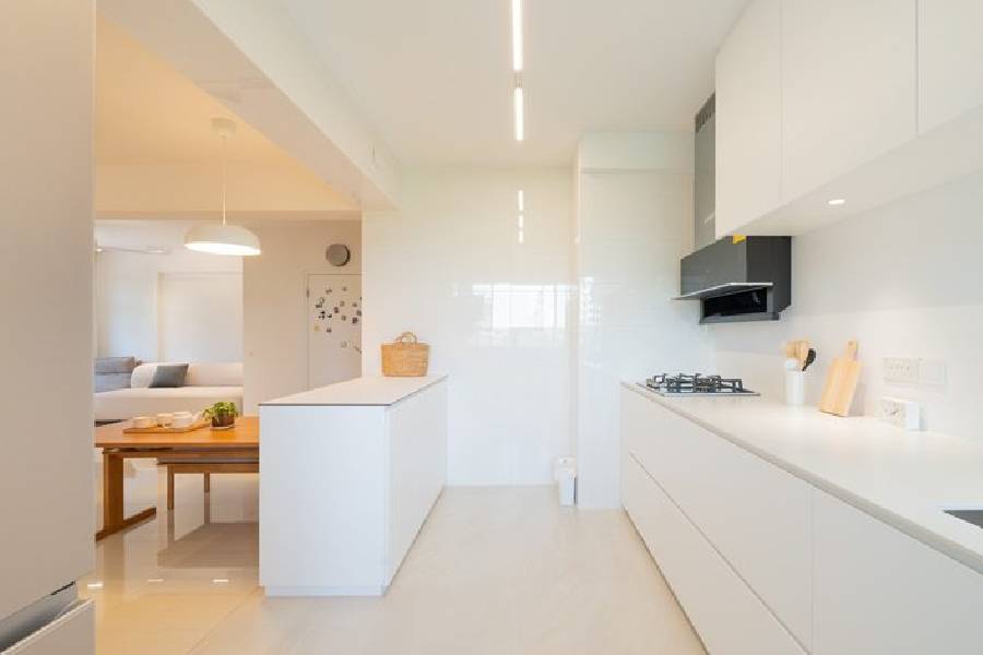 Minimalist white galley kitchen renovation with integrated lighting and gas hob