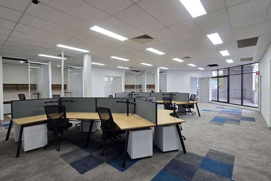 Office floor with partitioned workstation clusters and glass meeting rooms