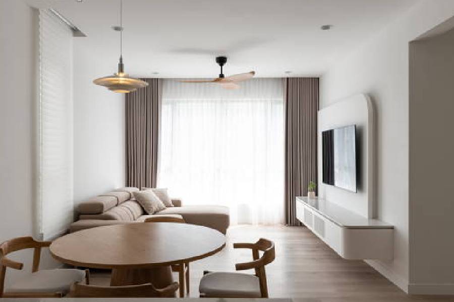 Resale flat living and dining space with round wood dining table and wall-mounted TV console